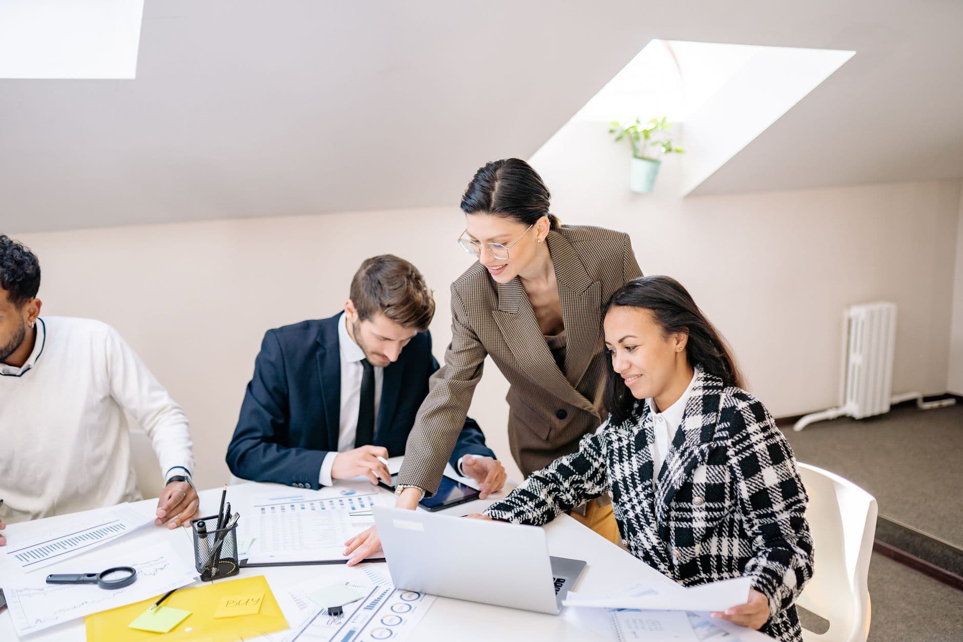 Small marketing agency team reviewing client work together on a laptop