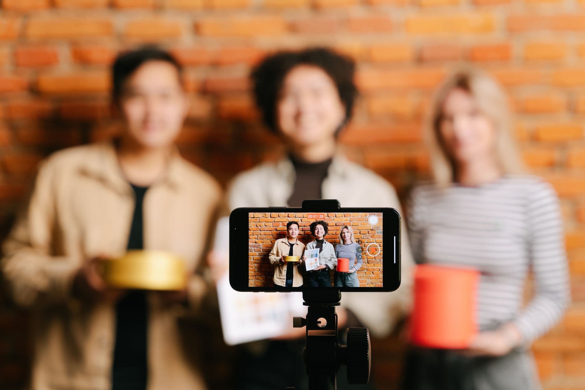 Business team recording a vertical product video on a smartphone in an office